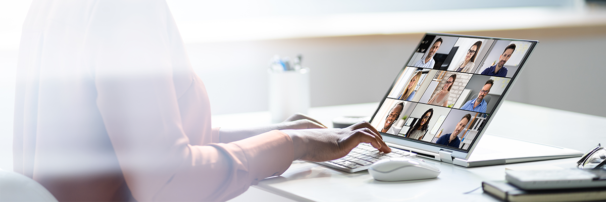 woman sitting at desk networking with peers on laptop